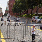 Un padre fotografía a su hijo en una de las últimas vallas que quedaban ayer en Moscú. MAXIM SHIPENKOV
