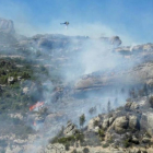 Descarga de agua de un helicóptero sobre las llamas del pantano de Margalef.