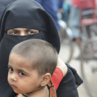 Una mujer musulmana sujeta a su hijo mientras camina por las calles de la ciudad de Nueva Delhi. EFE
