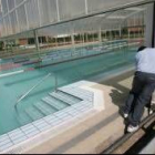 Un operario retira la cubierta de la piscina de Trobajo