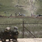 Palestinos se ponen a cubierto de los disparos de soldados en la frontera entre Siria e Israel.