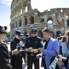 Dos agentes chinos, junto a dos italianos, revisan la documentación de un grupo de turistas chinos, en el exterior del Coliseo, en Roma, este lunes.
