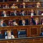 Una diputada del PSOE hace a sus compañeros una seña para indicar el sentido del voto