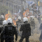 Los ganaderos participantes en la manifestación lanzan paja contra los antidisturbios, ayer, en Bruselas.