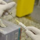 Un sanitario prepara la vacuna contra el virus de la gripe A.