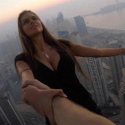 Viki Odintcova, de la mano de su asistente, sin arnés, a 300 metros de altura, a punto de hacerse un selfi de vértigo.