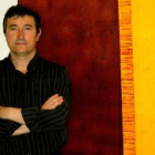 Julio Martínez, ante una de sus coloristas y enigmáticas obras.
