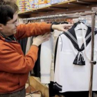 Un comerciante cuelga un traje de primera comunión en su tienda, en una imagen de archivo