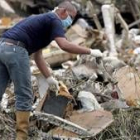 Un miembro del equipo de rescate rebusca entre los restos del avión