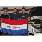 Los aficionados paraguayos Javier, Marcos y Óscar en el taller de reparación de coches.