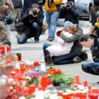 Varias personas se muestran apenadas ante el altar montado en el exterior de la escuela de Albertvil