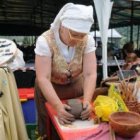 Una alfarera amasa el barro en una exhibición, ayer, en la feria de artesanía de Murias de Paredes.
