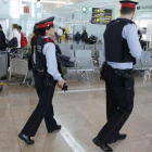 Dos 'mossos' participan en el servicio de vigilancia reforzada del aeropuerto de El Prat.