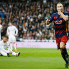Andrés Iniesta celebra la consecución del tercer gol del Barça, mientras los madridistas Modric, Sergio Ramos y Cristiano Ronaldo se muestran abatidos al fondo.