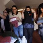 Cuatro de las Mujeres Anticrisis doblan las prendas cedidas al ropero.