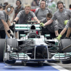 Mecánicos de Mercedes empujando el coche de Hamilton.