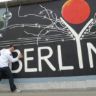 Manuel posa en el muro de Berlín, ahora convertido en una exposición de grafitis.