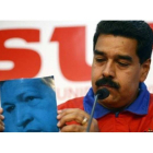Maduro muestra la portada de un libro de Hugo Chávez durante una conferencia de prensa, el día 11 en Caracas.