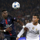 El delantero del Real Madrid, Cristiano Ronaldo, pelea por el control del balón con el jugador del París Saint Germain, Serge Aurier