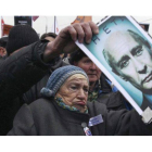 Una mujer sostiene una fotografía del primer ministro ruso Vladimir Putin en la que se puede leer "no" durante una manifestación contra su gobierno en Moscú.