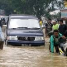 Los residentes de Brandan transitan por una calle inundada de la localidad