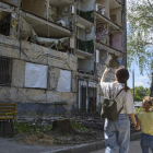 Una madre y su hija caminan por uno de los edificios destruidos de Járkov. SERGEY KOZLOV