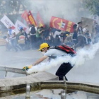 Un manifestante intenta sujetar una bomba lacrimógena, este domingo en Ankara.