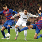 Piqué y Sergio Busquets presionan al portugués Cristiano Ronaldo, del Real Madrid, durante el partido de vuelta de los cuartos de final de la Copa del Rey.