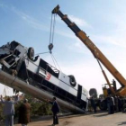 Una grúa iza el autobús que cayó en el canal de agua de Ibrahimiya