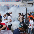 Aficionados ingleses corren tras el lanzamiento de gases lacrimógenos por la policía en Marsella.