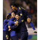 Ronaldinho salta sobre la piña de jugadores que celebran uno de los goles del Barcelona