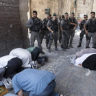 Los soldados israelíes contemplan el rezo de los palestinos en la Ciudad Vieja de Jerusalén. ABIR SULTAN