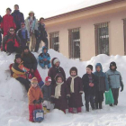 Escolares leoneses posan en la nieve ante su escuela.