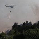 El helicóptero intenta evitar que las llamas lleguen a las viviendas, prácticamente cercadas por el fuego.