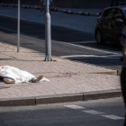 Un miliciano prorruso pasa frente a una persona muerta por el bombardeo a Donetsk.