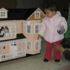 Una niña observa una casa de muñecas perteneciente a la exposición de maquetas