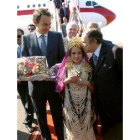 Una niña con el traje argelino recibe a Zapatero con un ramo de flores