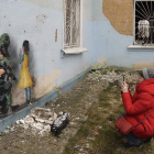 Una mujer fotografía una pintura en un muro de Jarkov. ANDRII NESTERENKO