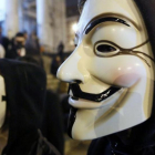 Manifestantes protestan en Bruselas con máscaras aludiendo a Anonymous.