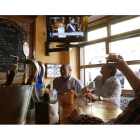 Un grupo de leoneses brinda por el nuevo rey mientras ven en la televisión del bar el acto de proclamación