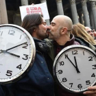 Una pareja con dos grandes relojes en la manifestación de Roma.