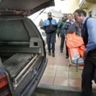 Empleados de la funeraria trasladan hasta el coche el cadáver de la mujer asesinada