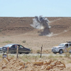 Un cohete lanzado por los leales a Gadafi explota lejos de un vehículo rebelde al norte de la ciudad de Bani Walid en Libia.