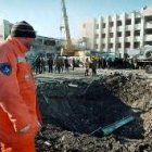 Un trabajador mira el cráter ocasionado por la explosión en Grozni