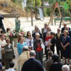 Los vecinos y autoridades enfrente de la bocamina durante la ofrenda floral a la virgen.