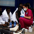 Varios inmigrantes son atendidos por los servicios sanitarios tras conseguir saltar la valla. F. GUERRERO