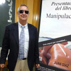 El periodista Juan Díaz, junto a la portada de su novela.