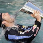 Mark Webber se baña en una piscina con el trofeo.