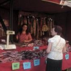 Una mujer observa la oferta de un puesto de embutidos