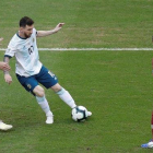 Messi controla un balón, vigilado por jugadores de Qatar.